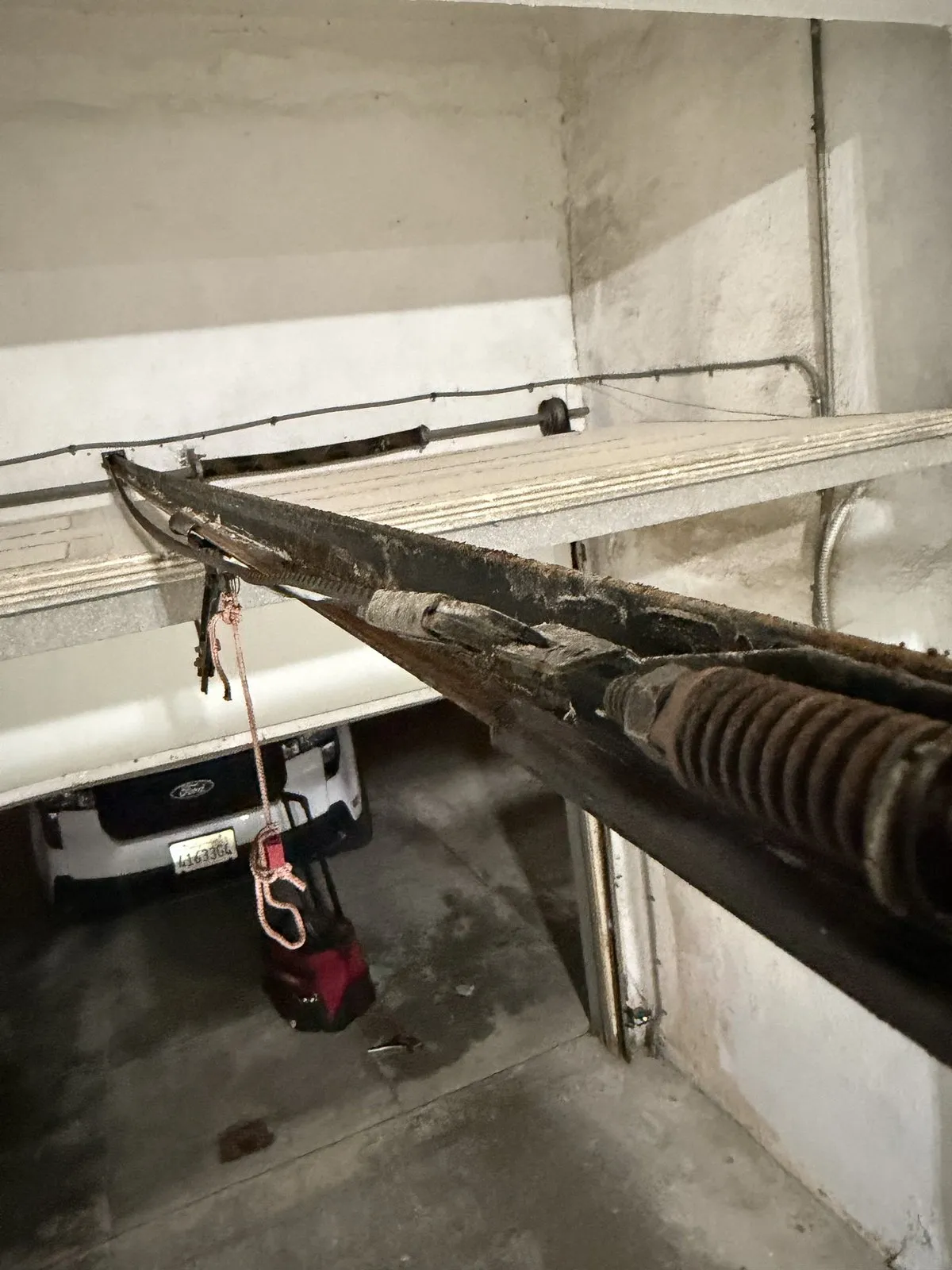 A worn opener rail and motor unit showing surface rust
